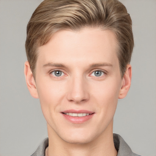 Joyful white young-adult male with short  brown hair and grey eyes