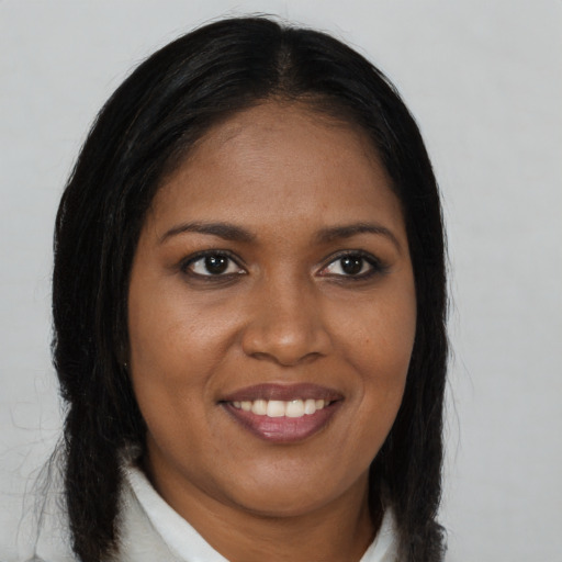 Joyful black young-adult female with long  brown hair and brown eyes