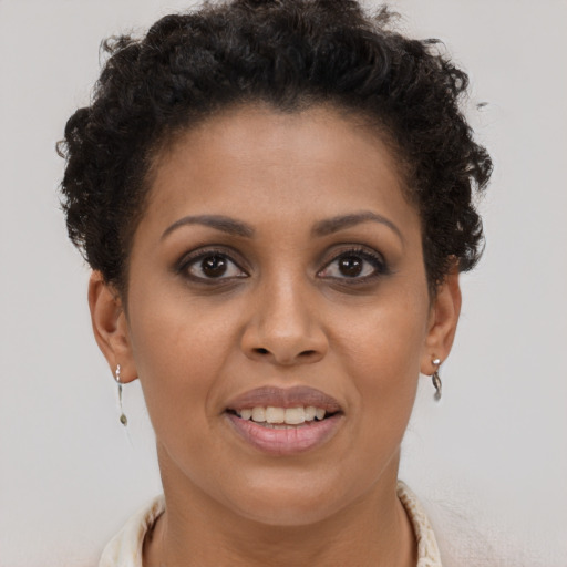 Joyful black young-adult female with short  brown hair and brown eyes