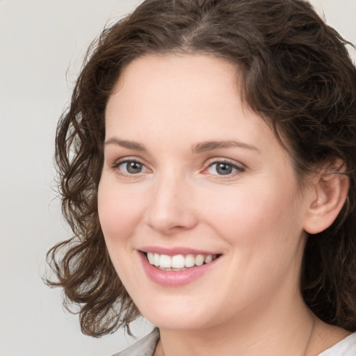 Joyful white young-adult female with medium  brown hair and green eyes