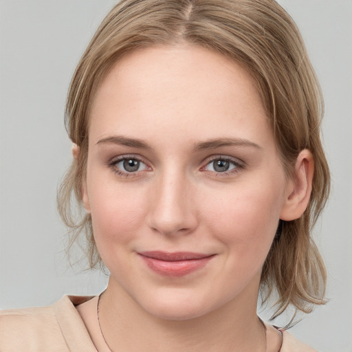 Joyful white young-adult female with medium  brown hair and blue eyes