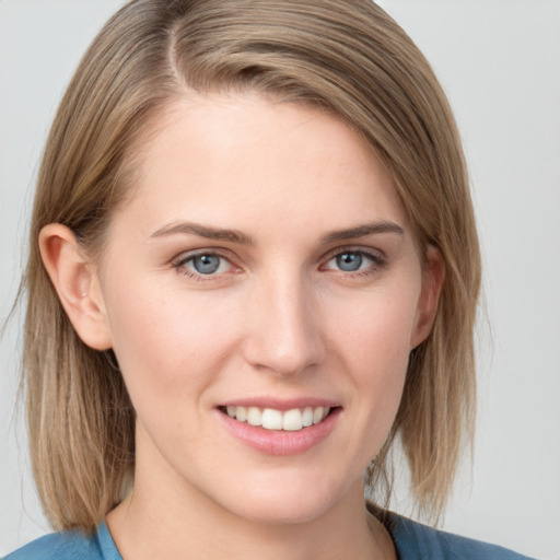 Joyful white young-adult female with medium  brown hair and blue eyes