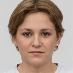 Joyful white young-adult female with medium  brown hair and grey eyes