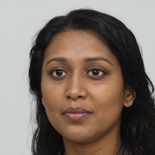 Joyful black young-adult female with long  black hair and brown eyes