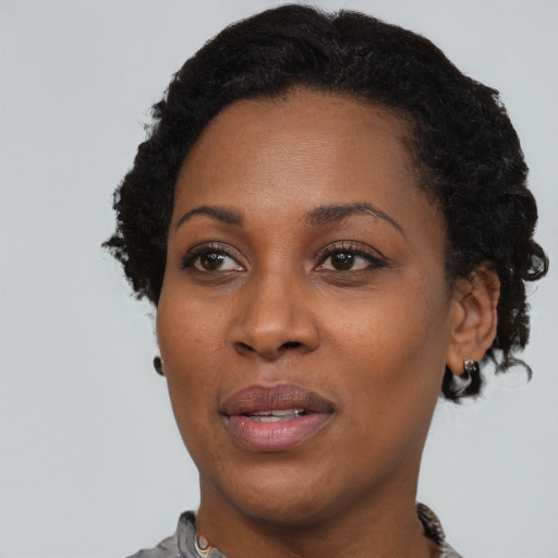Joyful black adult female with short  black hair and brown eyes