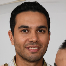 Joyful latino young-adult male with short  brown hair and brown eyes