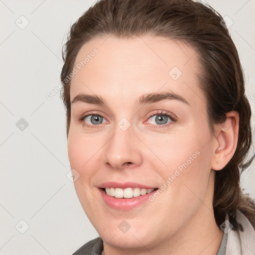 Joyful white young-adult female with medium  brown hair and grey eyes