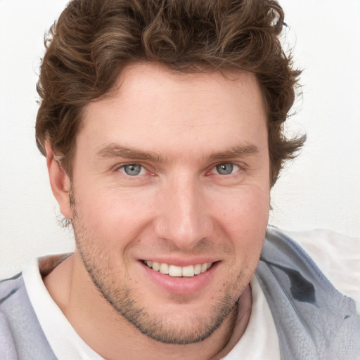 Joyful white young-adult male with short  brown hair and blue eyes