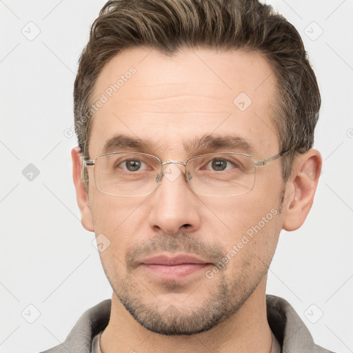 Joyful white adult male with short  brown hair and grey eyes