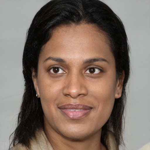 Joyful latino adult female with medium  brown hair and brown eyes