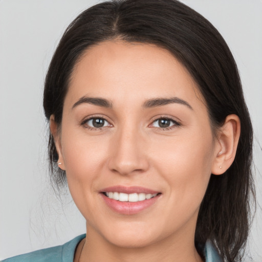 Joyful white young-adult female with long  brown hair and brown eyes