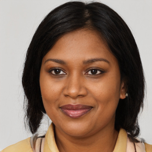 Joyful black young-adult female with medium  brown hair and brown eyes