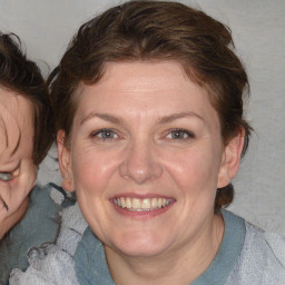 Joyful white adult female with medium  brown hair and blue eyes