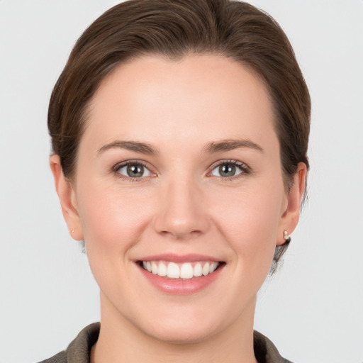 Joyful white young-adult female with short  brown hair and grey eyes