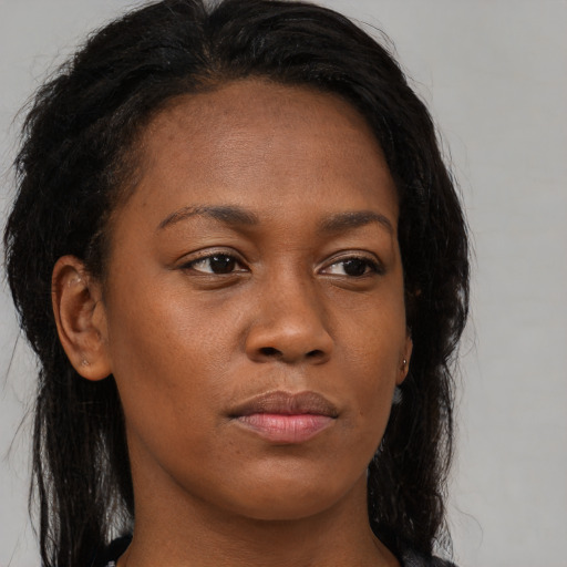 Joyful black young-adult female with long  brown hair and brown eyes