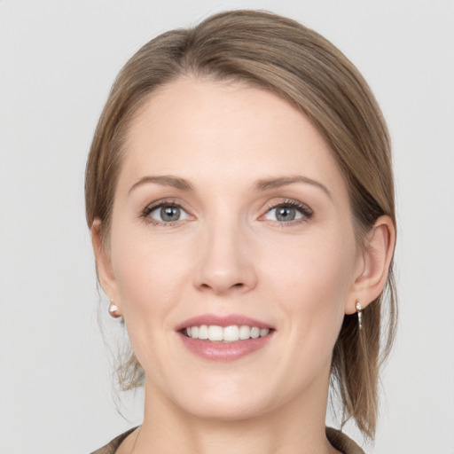 Joyful white young-adult female with medium  brown hair and grey eyes