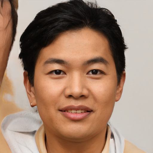 Joyful asian young-adult male with short  brown hair and brown eyes