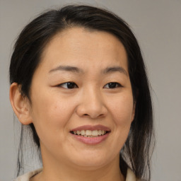 Joyful asian adult female with medium  brown hair and brown eyes