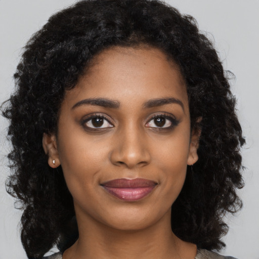 Joyful black young-adult female with long  black hair and brown eyes