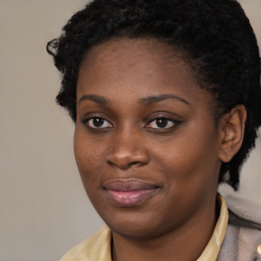 Joyful black young-adult female with short  black hair and brown eyes