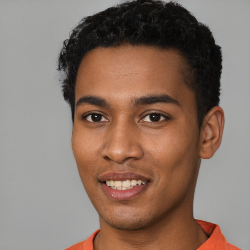 Joyful black young-adult male with short  brown hair and brown eyes