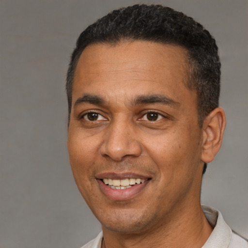 Joyful black adult male with short  brown hair and brown eyes