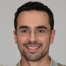 Joyful white adult male with short  black hair and brown eyes