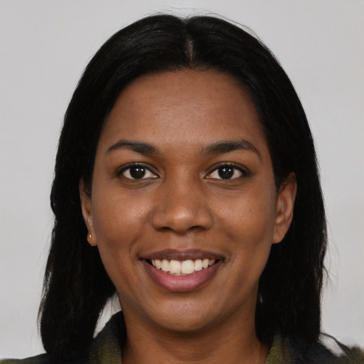 Joyful black young-adult female with long  black hair and brown eyes