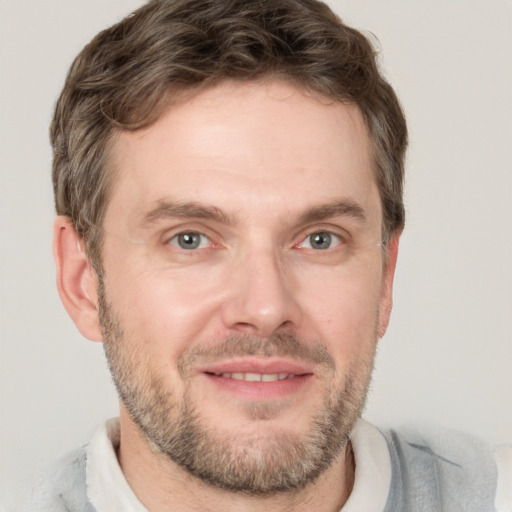 Joyful white adult male with short  brown hair and grey eyes