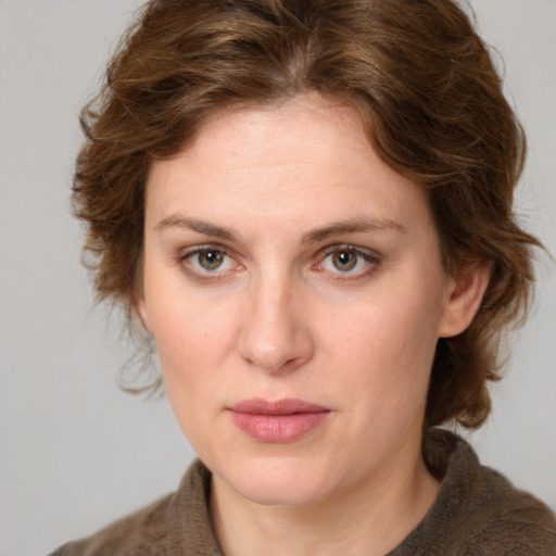 Joyful white young-adult female with medium  brown hair and green eyes