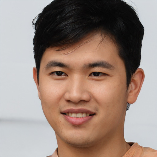 Joyful asian young-adult male with short  black hair and brown eyes