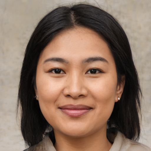 Joyful asian young-adult female with medium  black hair and brown eyes