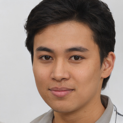Joyful asian young-adult male with short  brown hair and brown eyes