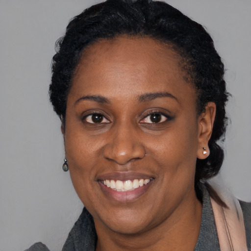 Joyful black adult female with short  black hair and brown eyes