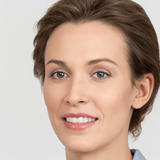 Joyful white young-adult female with medium  brown hair and grey eyes