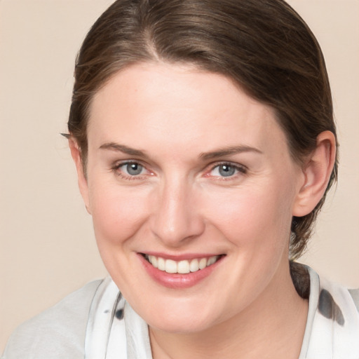 Joyful white young-adult female with medium  brown hair and blue eyes