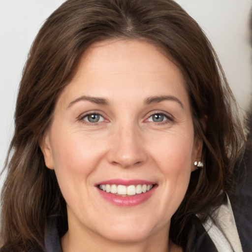 Joyful white adult female with medium  brown hair and grey eyes