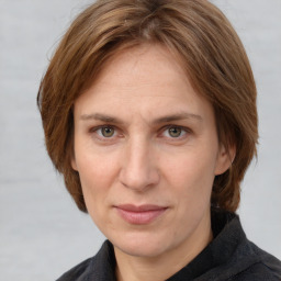 Joyful white adult female with medium  brown hair and grey eyes