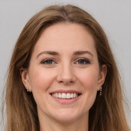 Joyful white young-adult female with long  brown hair and grey eyes