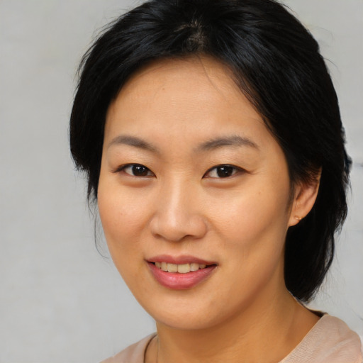 Joyful asian young-adult female with medium  brown hair and brown eyes