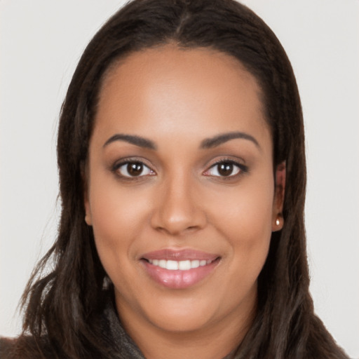 Joyful latino young-adult female with long  brown hair and brown eyes