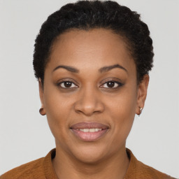 Joyful black young-adult female with short  brown hair and brown eyes
