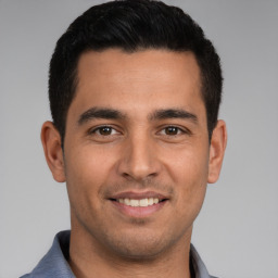 Joyful white young-adult male with short  black hair and brown eyes