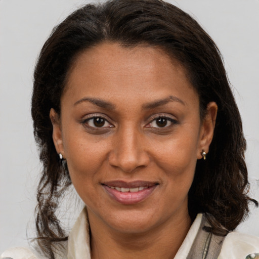 Joyful latino adult female with medium  brown hair and brown eyes