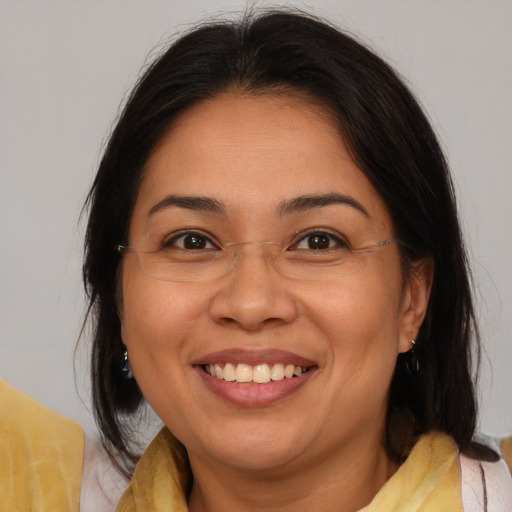 Joyful latino adult female with medium  brown hair and brown eyes