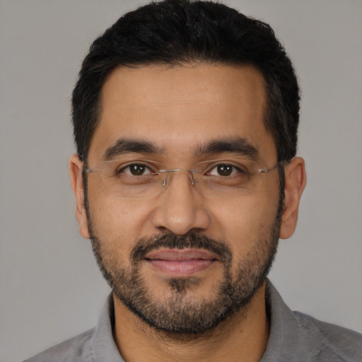Joyful latino adult male with short  black hair and brown eyes