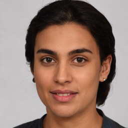 Joyful latino young-adult female with medium  brown hair and brown eyes