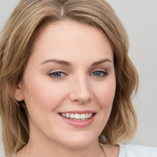 Joyful white young-adult female with medium  brown hair and green eyes