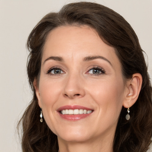 Joyful white adult female with medium  brown hair and grey eyes