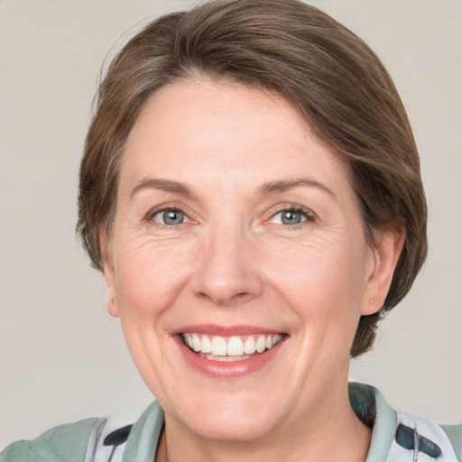 Joyful white adult female with medium  brown hair and grey eyes